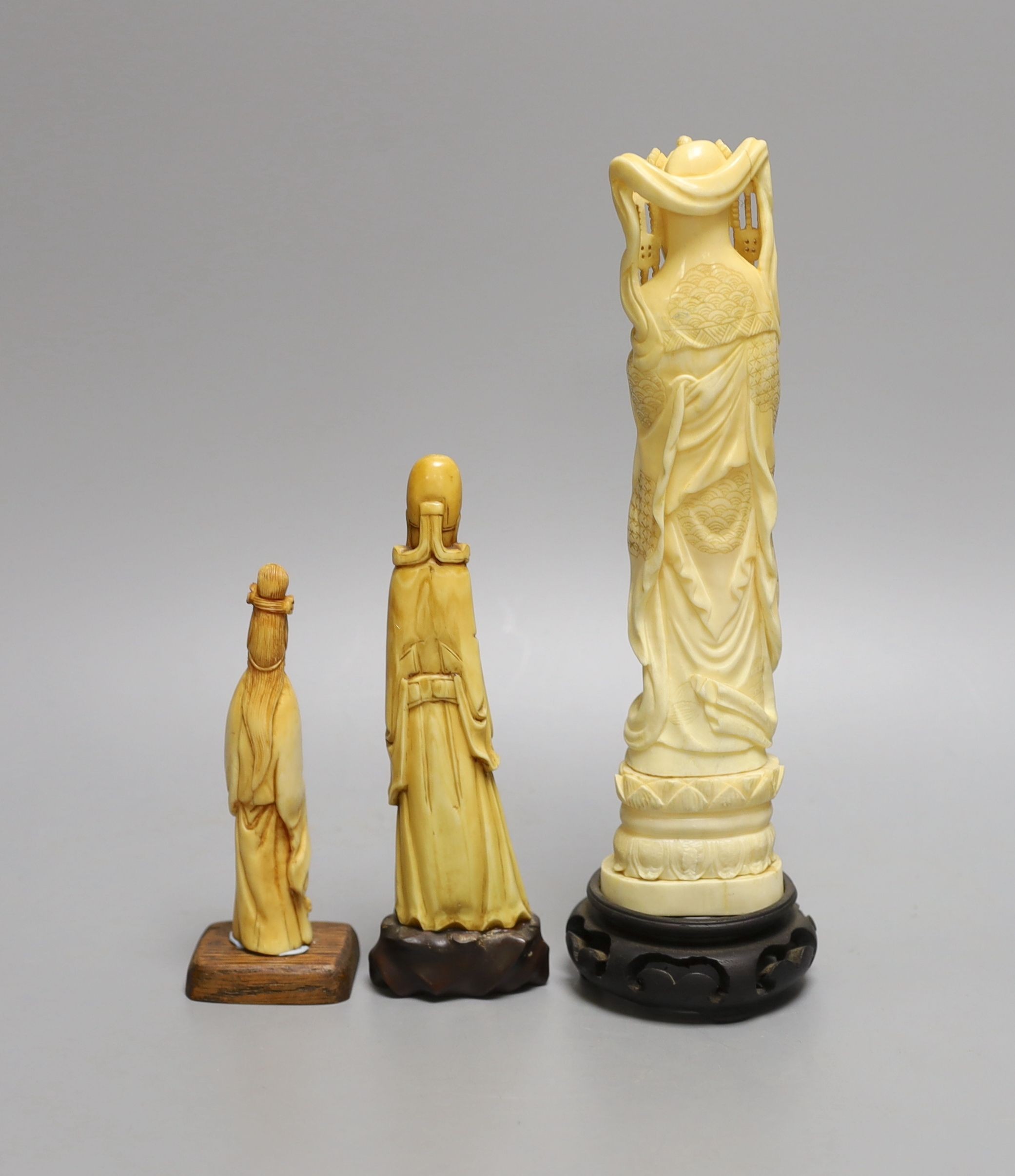 A Japanese walrus ivory figure of Kwannon and two Chinese hippo tusk? figures, early 20th century (3), wood stands, tallest 24cm (including base)